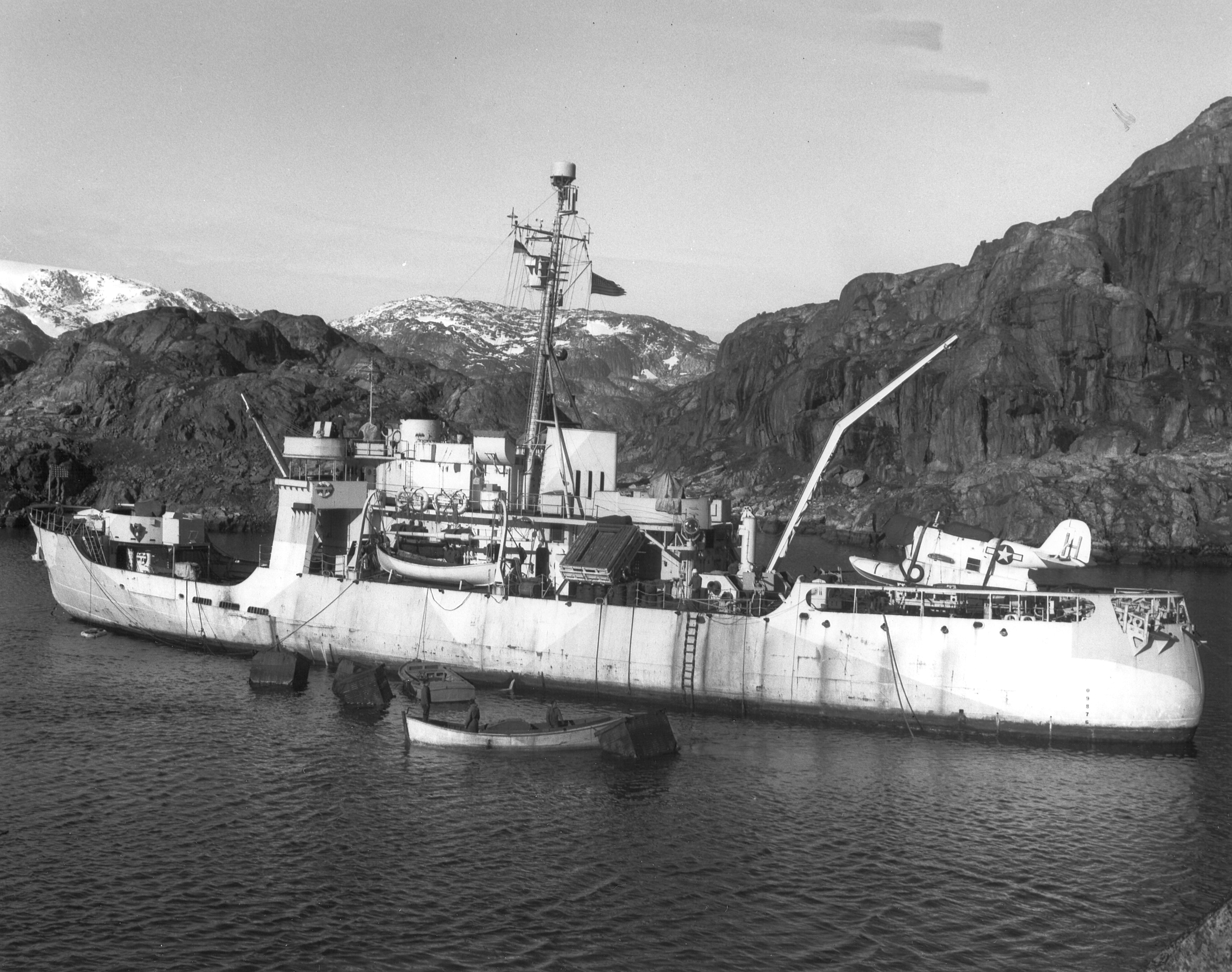 A 1945 photograph of Storis at anchor in Greenland displaying her deck and anti-aircraft guns, faded ice camouflage hull paint, as well as depth charge racks and a Grumman J2F “Duck” amphibian aircraft. (U.S. Coast Guard) A 1945 photograph of Storis at anchor in Greenland displaying her deck and anti-aircraft guns, faded ice camouflage hull paint, as well as depth charge racks and a Grumman J2F “Duck” amphibian aircraft. (U.S. Coast Guard)
